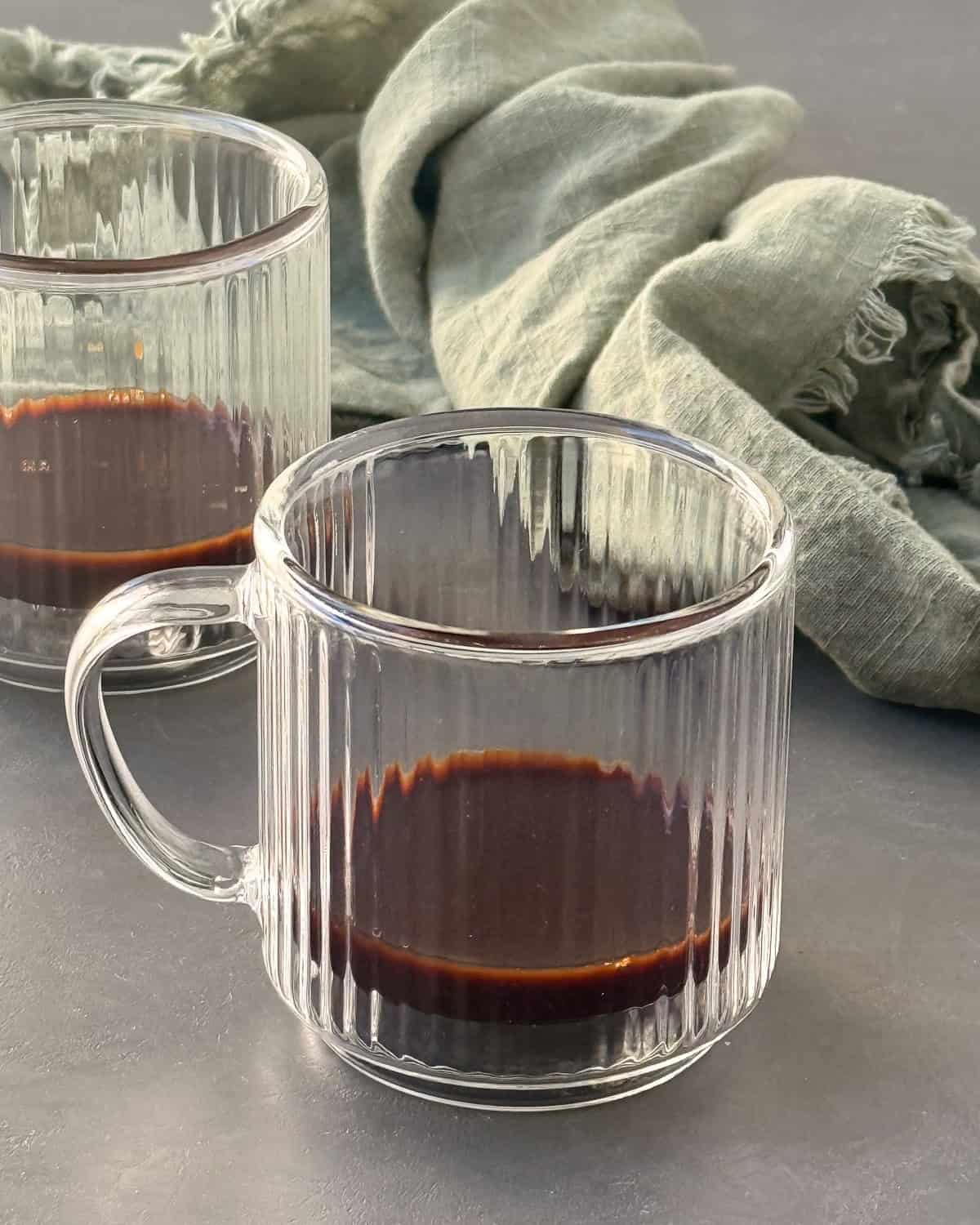 Two glass cups with a shot of espresso in it.