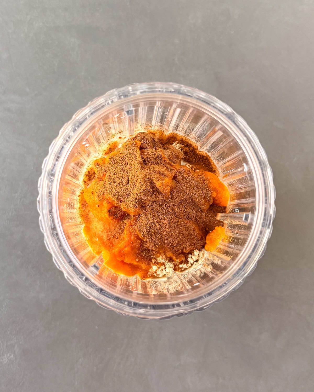Pumpkin pie protein shake ingredients in a blender cup.