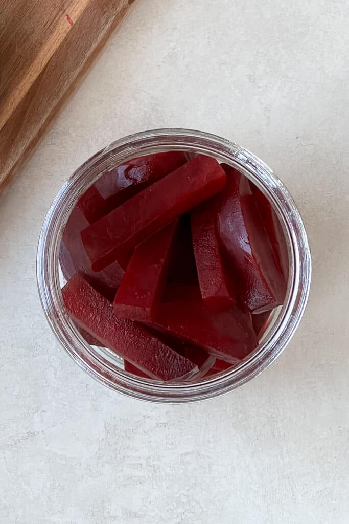 Sliced beets in a glass jar.