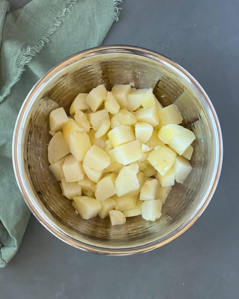 Boiled potatoes chunks in a mixing bowl.