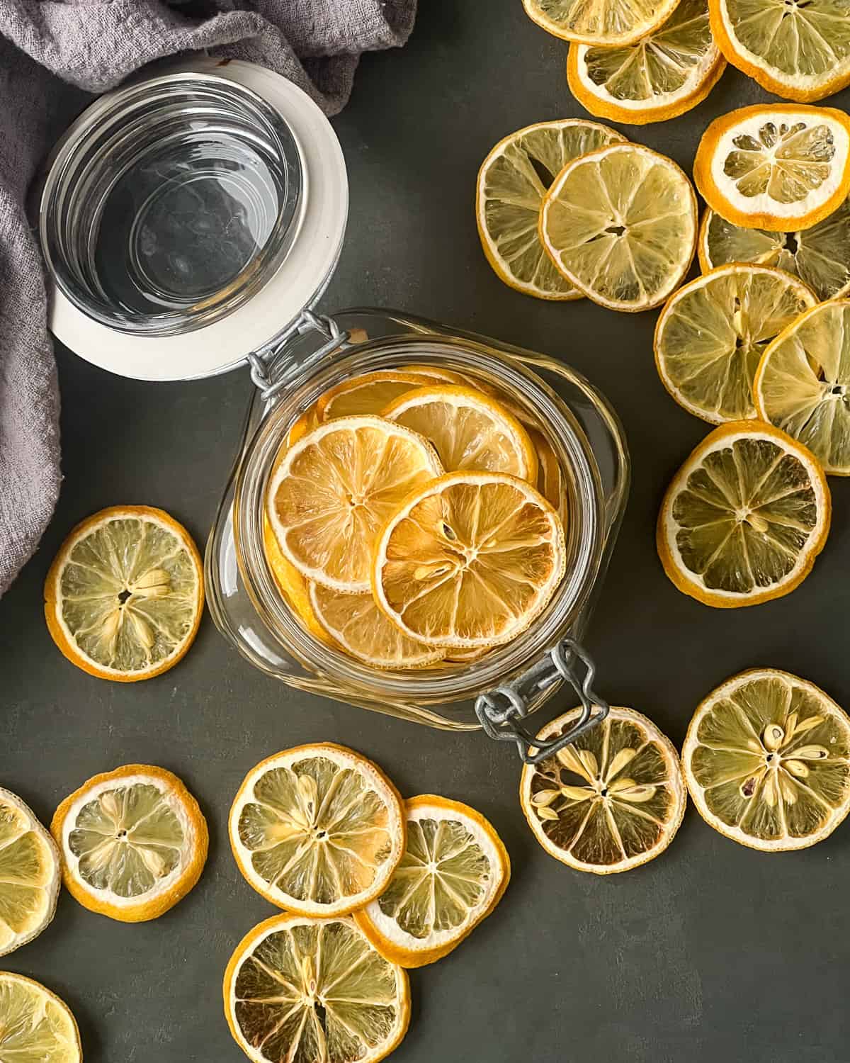 Dried lemon slices in an open lid wide mouth glass jar.