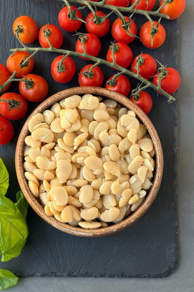 Cooked butter beans in a wooden bowl.
